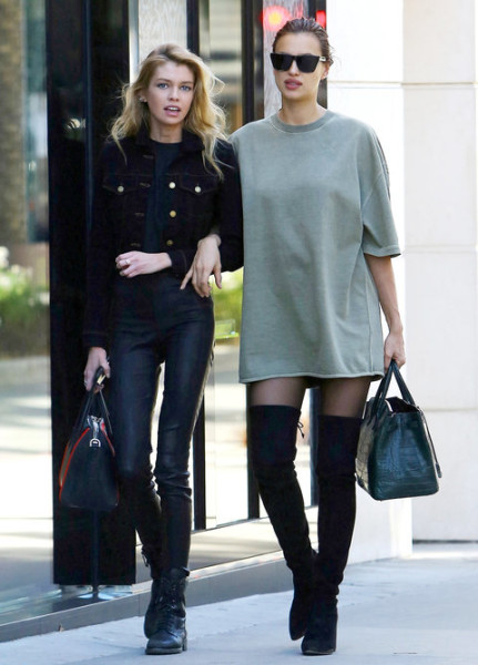 During an outing with her pal Stella Maxwell, the expectant star turned heads in an oversize Yeezy tee, black suede over-the-knee boots, and cool shades.